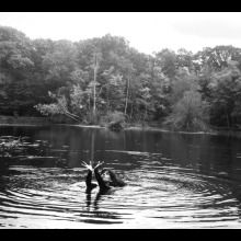 Nicole Antebi posing for a photo in a lake, black and white.